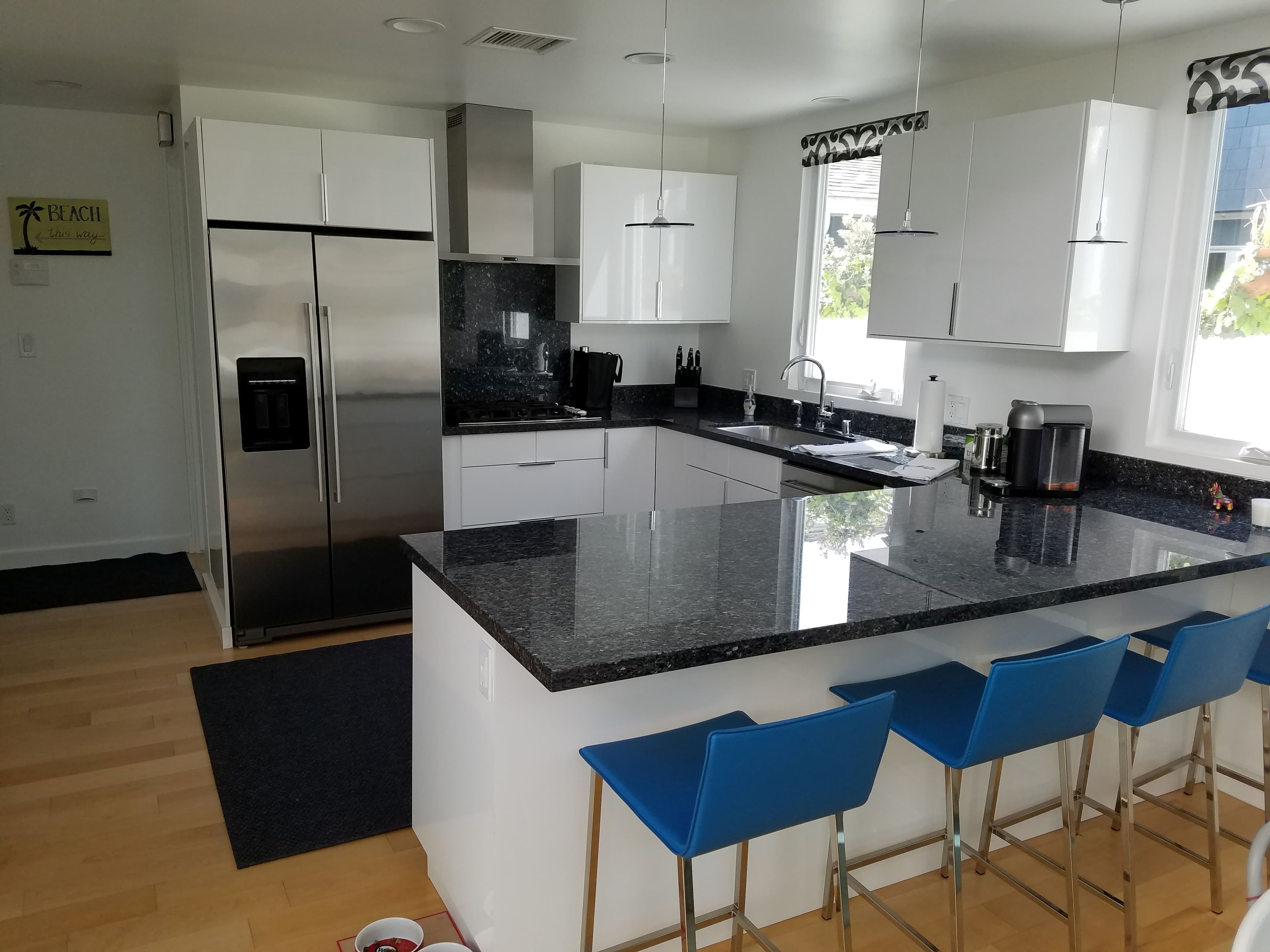 Modern kitchen with white gloss cabinets and dark granite island